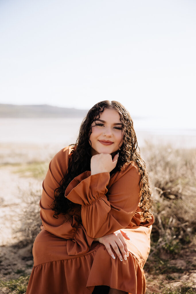 Maleah kneeling down for her senior pictures with Lxclusives Photography.